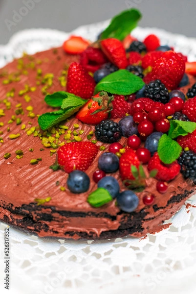 Fototapeta Delicious vegetarian chocolate cake with berries and pistachio 
