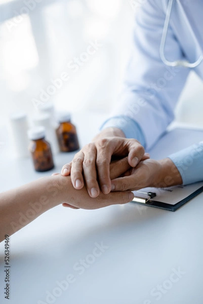 Fototapeta Doctor shook hands to encourage the patient after informing the results of the examination and informing the patients about treatment guidelines and prescribing medicines. Disease examination concept.