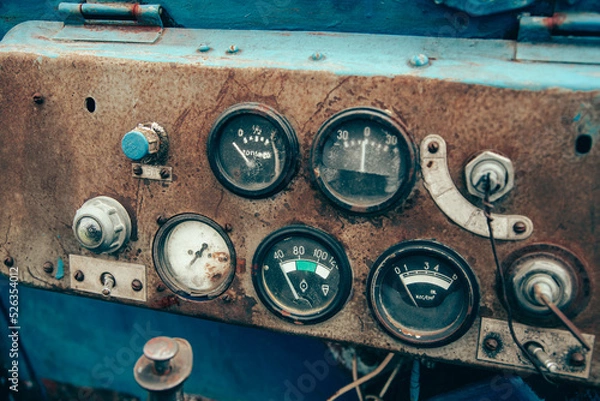 Fototapeta The rusty steel dashboard of a very old tractor close-up