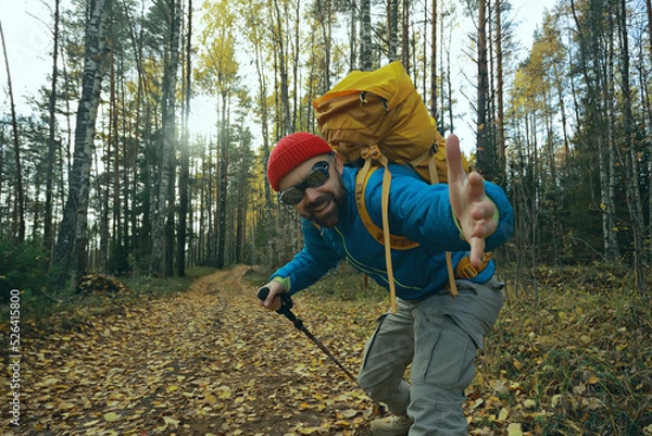 Fototapeta follow me on a hike, a man invites you to a forest hike, autumn landscape in the forest in nature