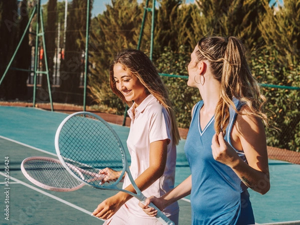 Fototapeta Amigas felices jugando al tenis al aire libre durante el verano