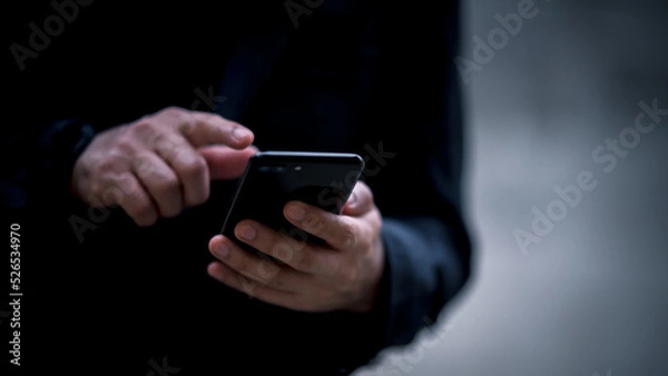Fototapeta Close up on casual Man using smart phone, using mobile smart phone and online working on laptop computer at home office.