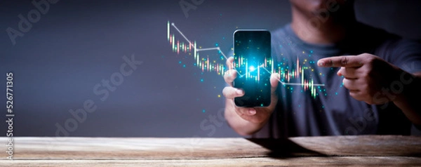 Fototapeta Stock market investments using tablets to analyze trading data. smartphone with stock exchange graph on screen. Business design for web banner.