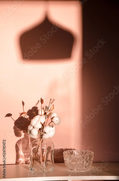 Fototapeta Abstract nature scene with composition of glass and dry branches of cotton. Neutral beige background for cosmetic, beauty product branding, identity and packaging.