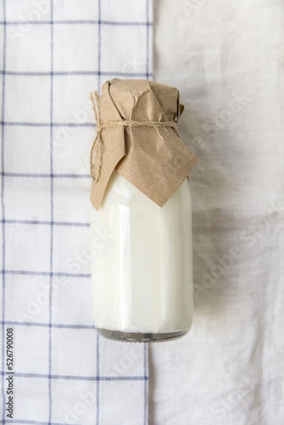 Obraz Ayran in a glass bottle on a light fabric background