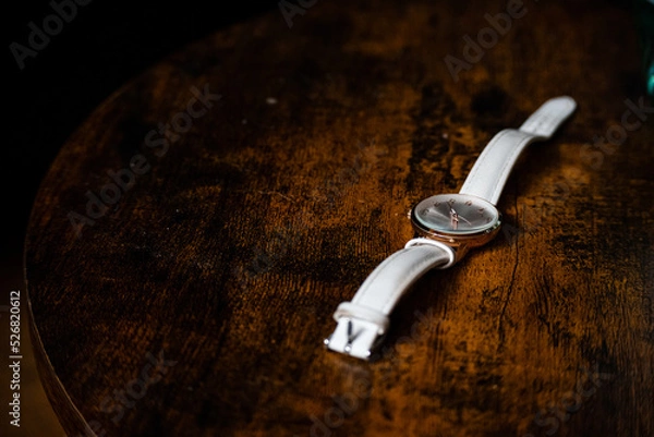 Obraz A watch laying on a dark wooden table