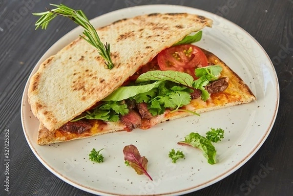 Obraz Pita bread filled with meat, vegetables and herbs. Breakfast or lunch. A dish from the chef for serving in a restaurant.