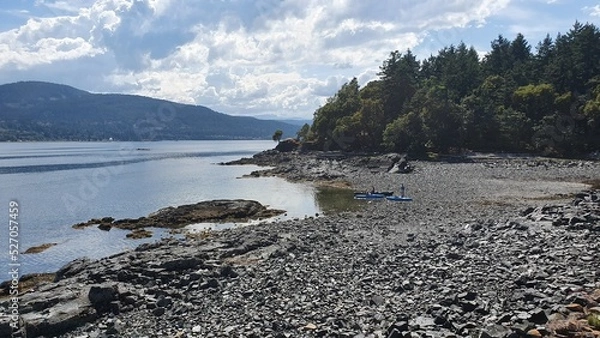Fototapeta Kayaks and canoe on pebble beach on Vancouver Island