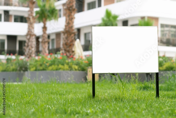 Fototapeta Empty template, advertising mock-up, banner on grass near pavement in city green park.Copy space for text.Information board on white background. 