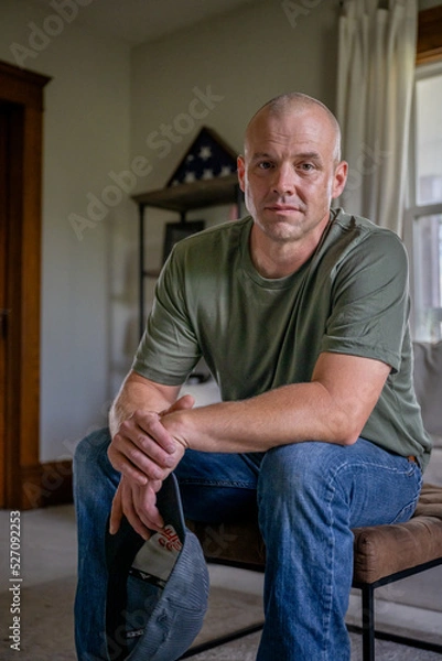 Fototapeta Marine veteran at home with family poses for portrait.