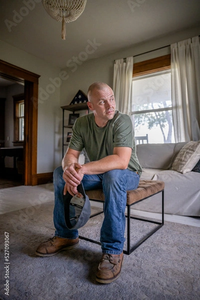 Fototapeta Marine veteran at home with family poses for portrait.