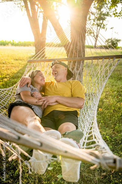 Fototapeta Marine veteran spends time with his wife in a hammock at sunset.