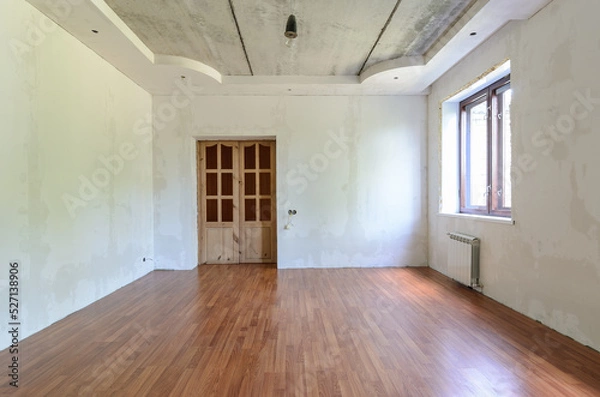 Fototapeta The interior of an empty room with a fine renovation, a laminate is laid on the floor