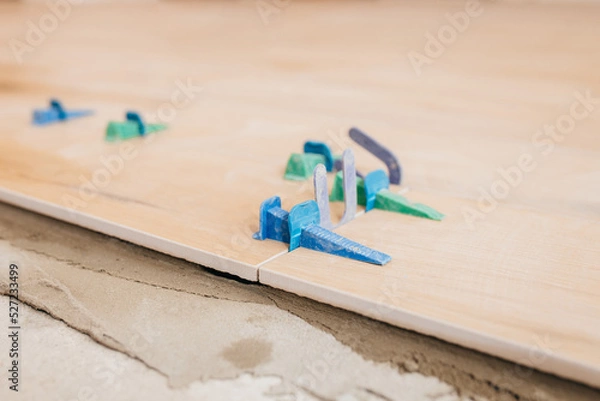 Fototapeta Close up tile leveling system on the floor. Plastic clips for bonding tiles
