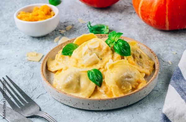 Fototapeta Homemade Pumpkin Ravioli with sauce and bsil on concrete background. Autumn food concept. Selective focus