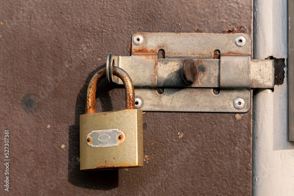 Obraz Old Metal Brown Door With A Handle And A Padlock. Red Rust Spots On Brown Paint.