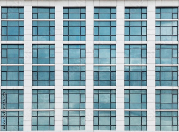 Obraz The glass window pattern on the building wall with the cloud reflection.