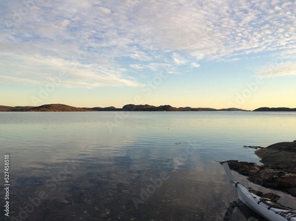 Fototapeta Kayak in the water in Greenland Fjord at sunrise
