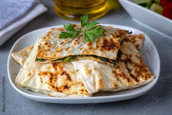 Fototapeta Traditional Turkish food, Turkish pancake gozleme with cheese and herb. The appetizer is Turkish pastry. There are varieties such as cheese, spinach, potato.