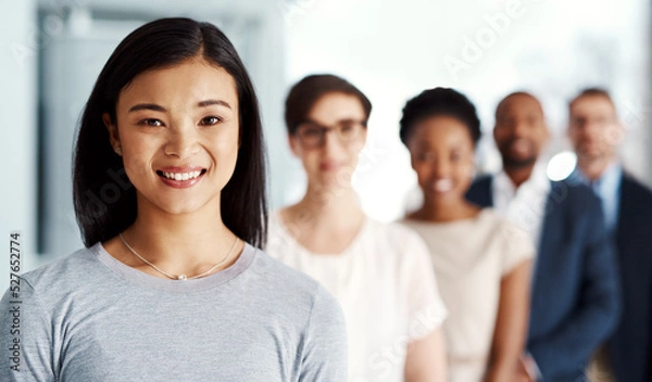 Fototapeta Happy business woman with team, looking confident and standing with employees at a startup company. Portrait of a manager, boss or female expressing leadership, teamwork and support with coworkers