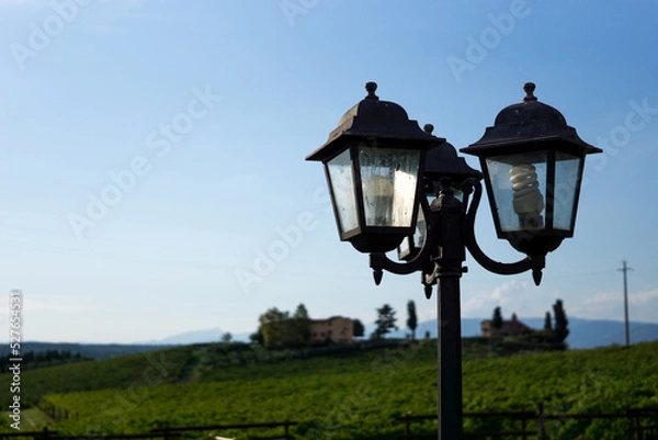 Fototapeta Photograph of a vintage lamppost with cloudy background and blue sky.
