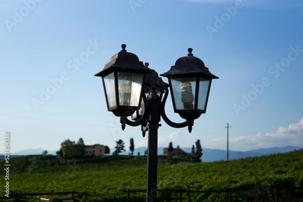Fototapeta Photograph of a vintage lamppost with cloudy background and blue sky.