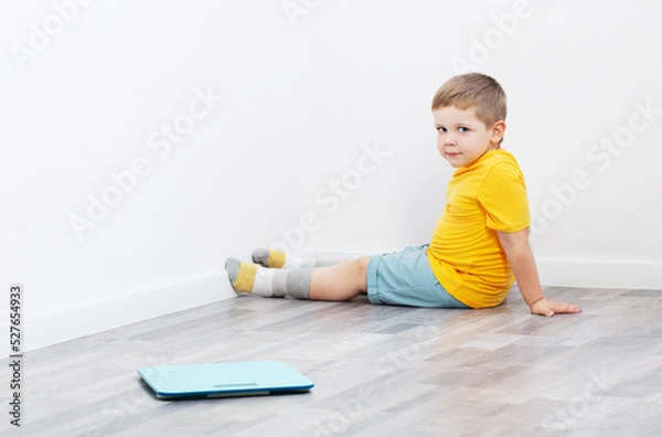 Obraz overweight little boy on scales at home