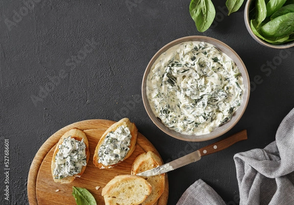 Obraz Spinach appetizer or dip with bread, top view, dark background, copy space