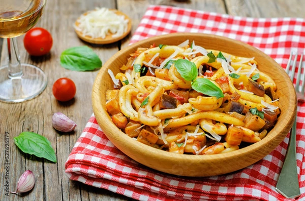 Obraz Eggplant tomato basil pasta in a plate on a wood backround