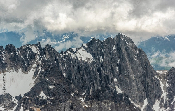 Fototapeta Mountain Range with Snow and Clouds