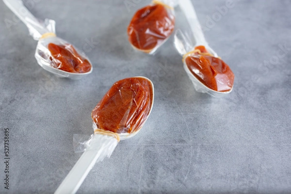 Fototapeta A closeup view of several tamarind candy spoons.