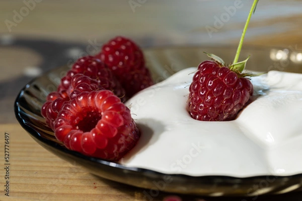 Obraz On a plate of sour cream and raspberries close-up delicious dessert.