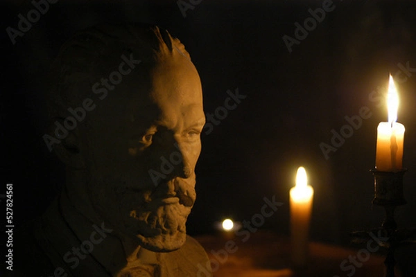 Fototapeta Gypsum figure of the composer Tchaikovsky in the studio with lighting and filters effect from the candle cinematographic effect