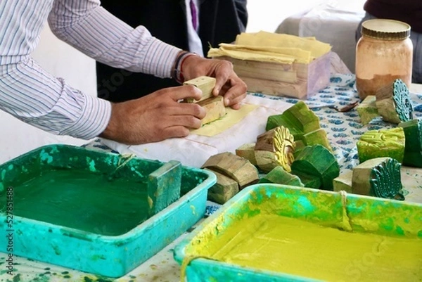 Fototapeta Handmade printed fabric cotton, showing process hand block printed pattern on textile with natural colors, green, yellow