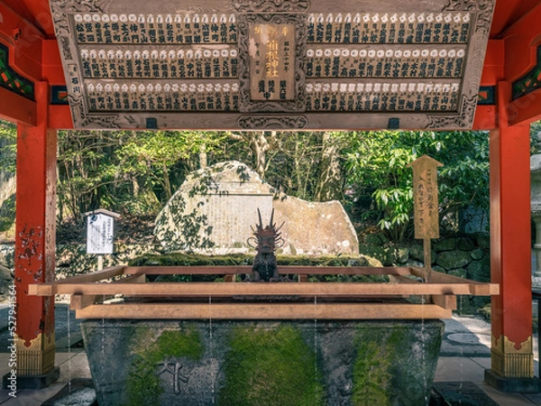 Fototapeta fountain with a wooden structure at the entrance of a japanese shinto shrine for purification