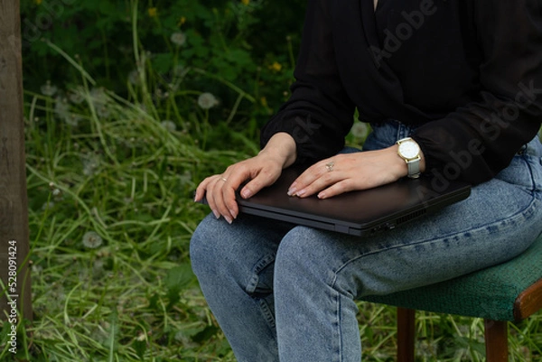 Fototapeta female hands are lying on the laptop, on the street, in the fresh air, the work is done, the work is over, the deal is approved,