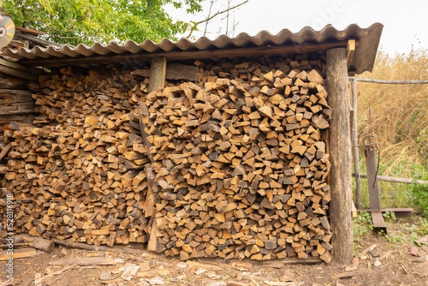 Fototapeta Background of firewood from chopped wood for kindling and heating the house. Woodpile with stacked firewood