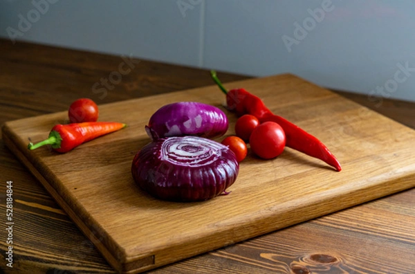 Obraz red and white onions on a wooden cutting board