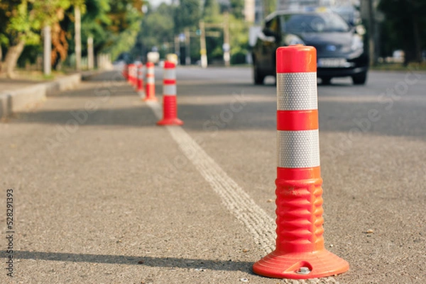 Fototapeta Anti-parking traffic cones on a bicycle path. Close-up, selective focus.