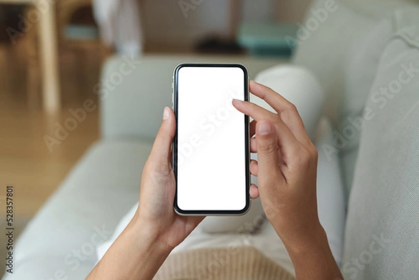 Obraz close-up hand using phone showing white screen in living room