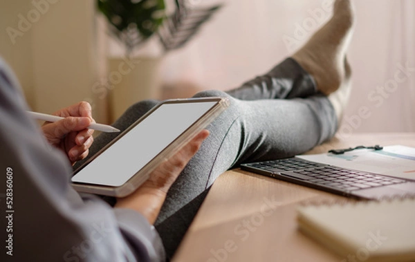 Obraz close up woman cross leg on table writing business plan using tablet at home