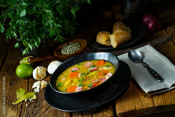 Fototapeta Hearty rustic pea soup with bacon and sausage