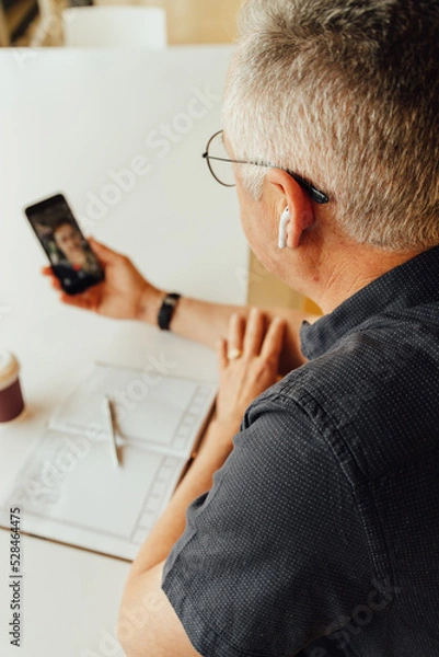 Obraz Mature businessman talking on video call in office