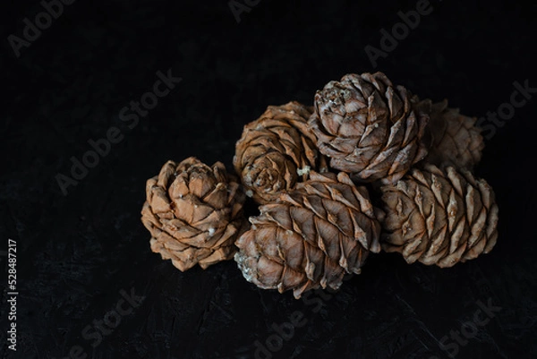 Obraz Cedar cones. Black background. Healthy food. Nuts