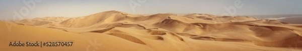 Fototapeta Travel to Africa, adventures, safari or expedition to Namib desert, panoramic view. Wilderness with sandy dunes of Namibia. Panoramic landscape of Sandwich Harbour, view on skyline and high hills.