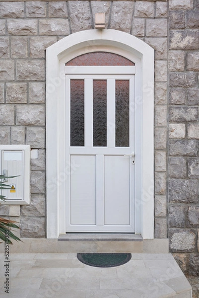 Obraz White plastic front door with glass on the facade of the house