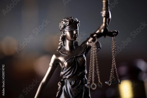 Fototapeta Law symbols composition. Law and justice concept.  Themis sculpture and judge’s gavel on gray background.