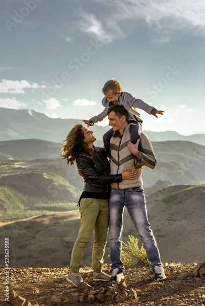 Obraz Happy family with father, mother and son walks in mountains together