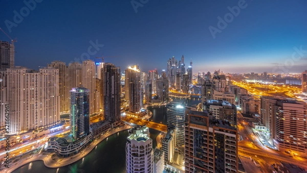 Fototapeta Panorama of various skyscrapers in tallest recidential block in Dubai Marina aerial night to day timelapse