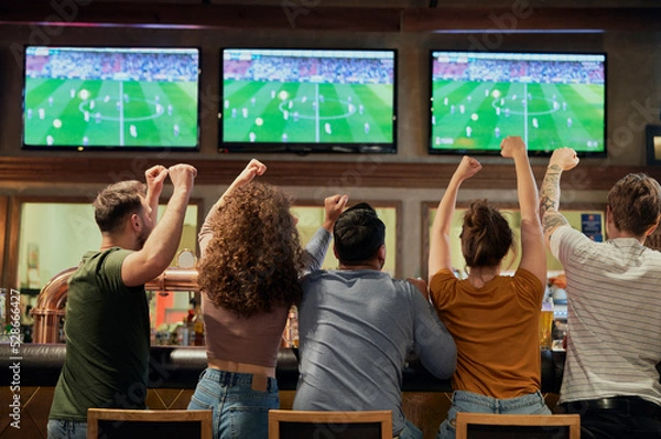 Obraz Cheering friends of soccer fans in the pub